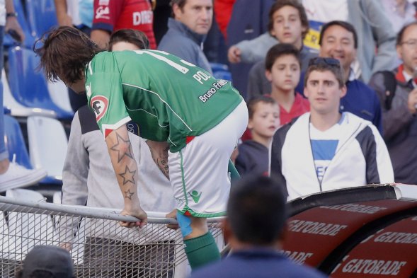 Marcos Sebastián Pol, delantero de Audax Italiano, se subió a la reja de la tribuna preferencial y agredió con un patada a Cristóbal Astorquiza, hincha del cuadro estudiantil. Marcos Sebastián Pol, delantero de Audax Italiano, se subió a la reja de la tribuna preferencial y agredió con un patada a Cristóbal Astorquiza, hincha del cuadro estudiantil.